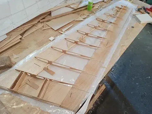 A wooden boat is being built in the process of being made.