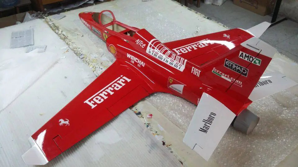 A red jet fighter plane sitting on top of a table.