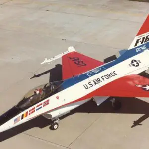 A red, white and blue jet fighter sitting on top of an airport runway.