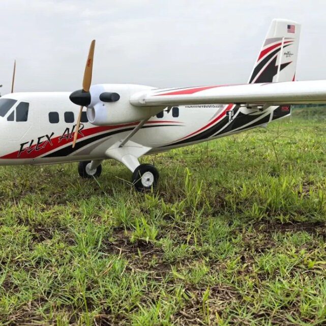 A small plane sitting in the grass near some water.